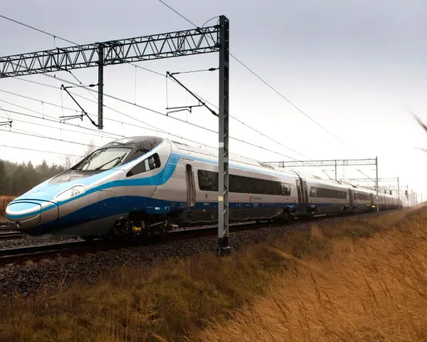 Nowoczesny Pendolino pędzi po torach, symbolizując rosnącą prędkość pociągów w Polsce.