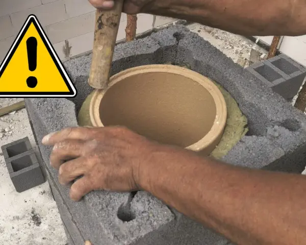 Ręce montują ceramiczny czopuch w konstrukcji z pustaków. Ostrzeżenie przed pracami budowlanymi.