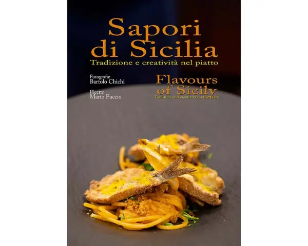 Un piatto di spaghetti con pesce fritto e scorza d'arancia, che celebra i sapori tipici siciliani.