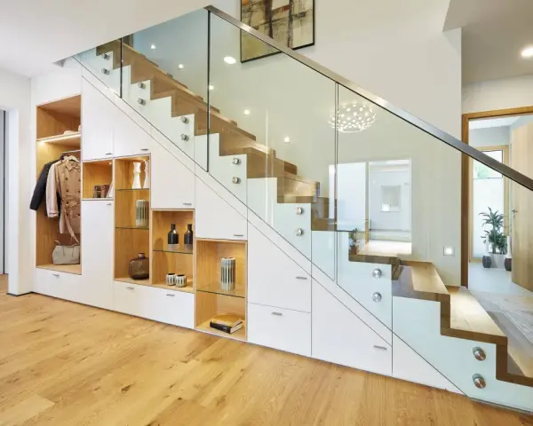 Schickes **schmales Reihenhaus einrichten**: Stauraumwunder unter der Treppe mit Garderobe, Regalen und Schubladen. Moderne Glasbrüstung.