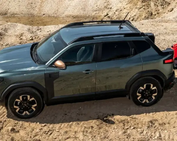 Zielony Dacia pickup z otwartą klapą bagażnika i czerwoną kanistrem na piasku.