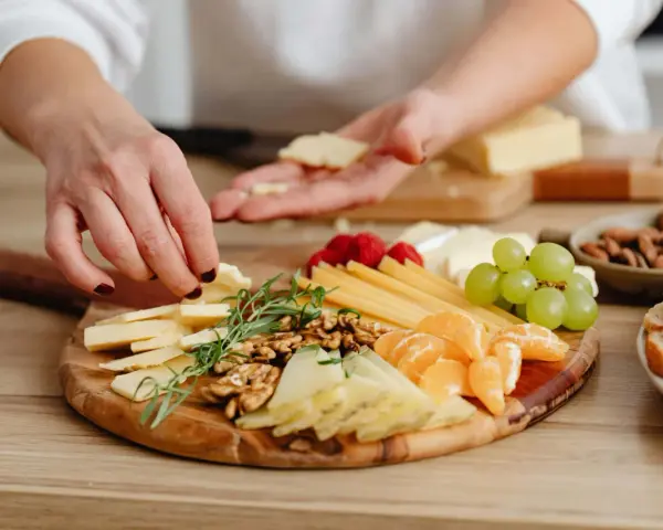Tabla de quesos variados, frutos secos, uvas y gajos de mandarina, perfecta para unos entrantes saludables.