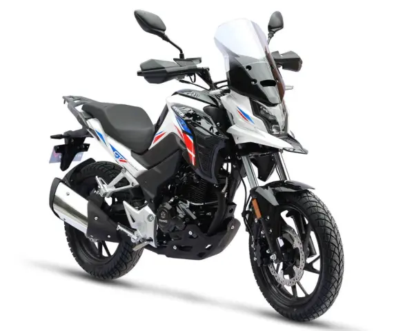 Nowy motocykl gotowy do docierania. Biało-czarny z czerwono-niebieskimi akcentami, z wysoką szybą i terenowymi oponami.