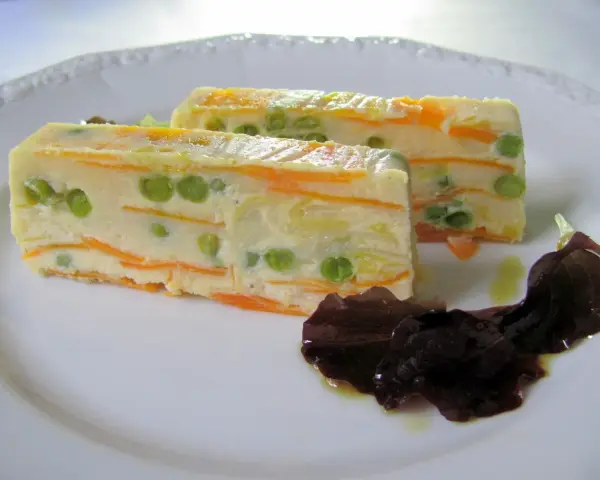 Zwei Scheiben Gemüseterrine mit Erbsen und Karotten, eine köstliche Vorspeise. Perfekt für Terrinen Rezepte.