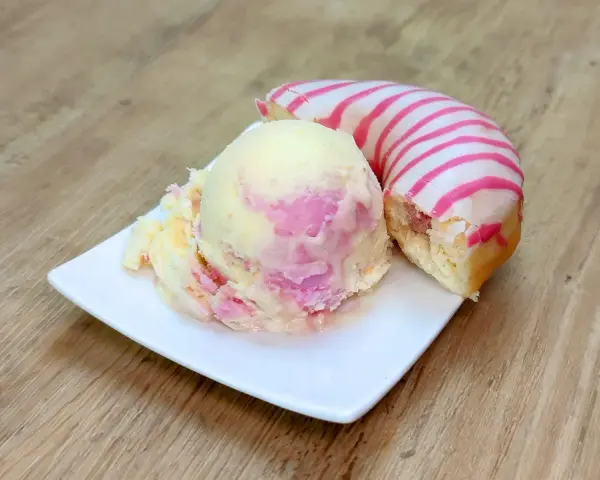 Ein cremiges Eis mit rosa Schlieren neben einem Donut mit rosa Streifen. Perfekt für eine süße Auszeit!