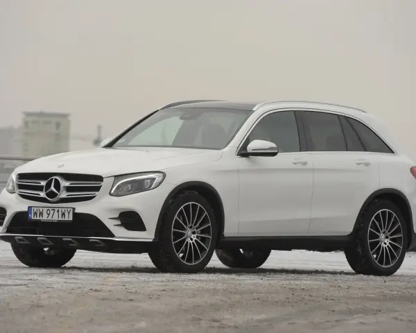 Biały Mercedes GLC 220d na tle miejskiego krajobrazu, gotowy na zimowe wyzwania.