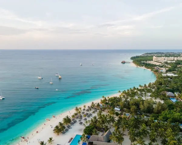 Rajska plaża na Zanzibarze z turkusową wodą, łodziami i luksusowymi hotelami. Sprawdź Zanzibar ceny i zaplanuj wymarzone wakacje!