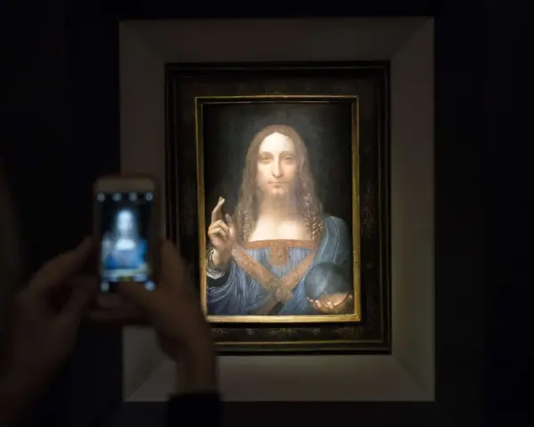 Persona toma foto a Salvator Mundi, el cuadro más caro del mundo, con su móvil.