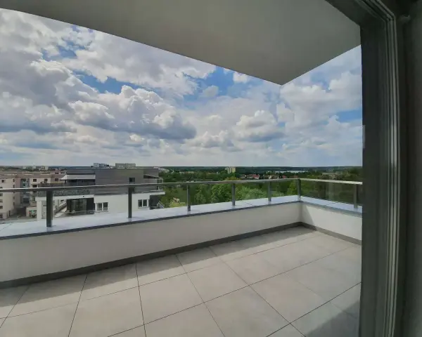Przestronna loggia z widokiem na miasto i zieleń. Idealne miejsce na poranną kawę.