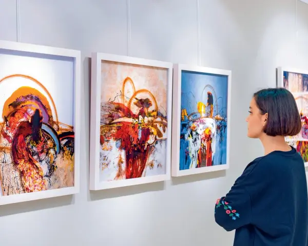 Kobieta ogląda abstrakcyjne obrazy w galerii sztuki.