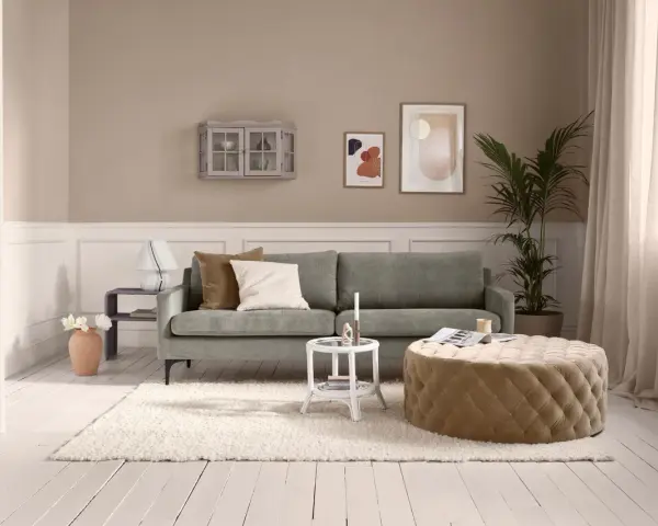 Gemütliches kleines Wohnzimmer einrichten mit grauem Sofa, beigem Hocker, weißem Teppich und Wanddeko.