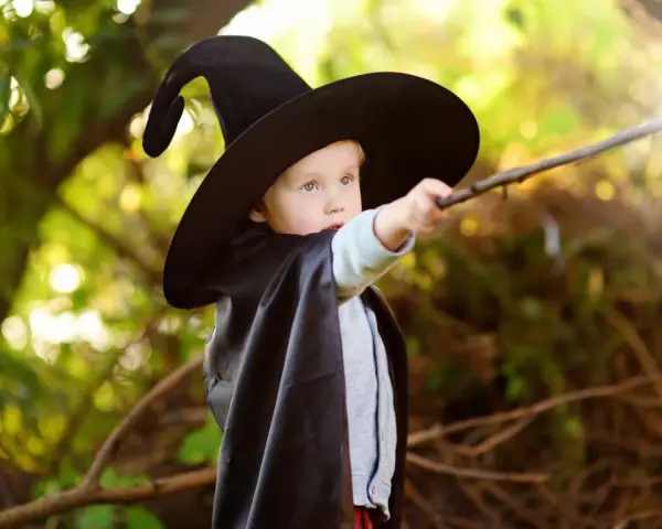 Kleiner Zauberer mit Hut und Stab, der die Welt verzaubert. Ein Beispiel für magisches Denken bei Kindern.