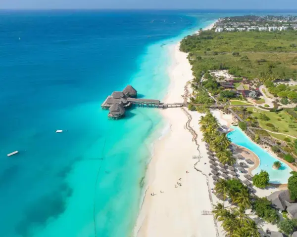 Rajskie plaże Zanzibar w lipcu: turkusowa woda, biały piasek, palmy i luksusowe bungalowy na wodzie. Idealne miejsce na wakacje.