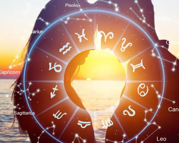 Zodiakalny krąg na tle zachodu słońca i sylwetek pary. Symbolika 2221 znaczenie w gwiazdach.