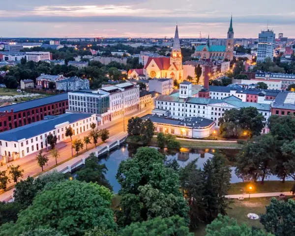 Widok na łódzką architekturę, w tym zabytkowe fabryki i kościoły. Idealne miejsce, by zobaczyć, co zwiedzić w Łodzi.