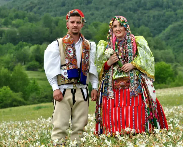 Para w tradycyjnych strojach na tle zielonych wzgórz. Ciekawe albania ciekawostki o kulturze i tradycji.