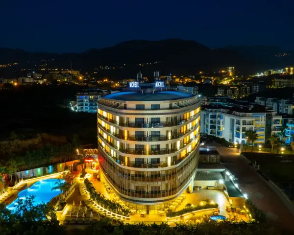 Nocny widok na lśniący hotel Michell z basenem i oświetlonymi pokojami. Wiele pozytywnych michell hotel spa opinie potwierdza jego urok.