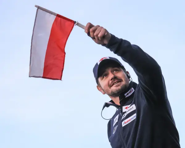Radosny kibic z polską flagą na skoki narciarskie mistrzostwa świata juniorów.