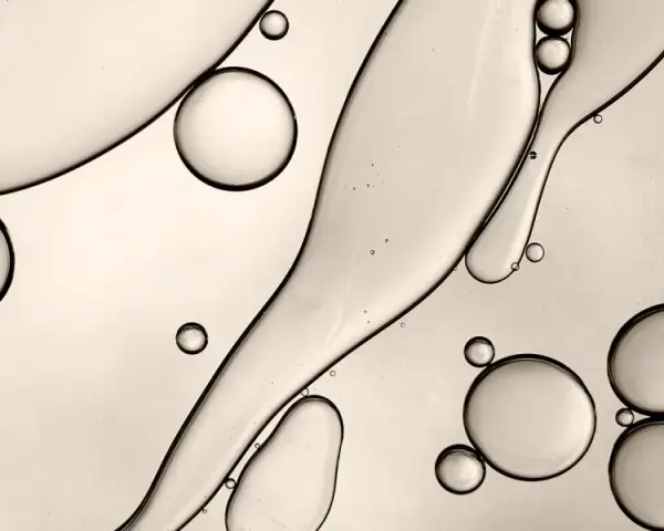 Gocce d'olio e acqua creano forme astratte, ricordando la struttura di un c13-15 alkane.
