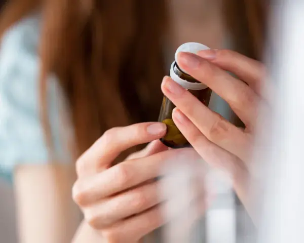 Dłonie otwierają buteleczkę z tabletkami, być może dulsevia 30, by zacząć nowy dzień.