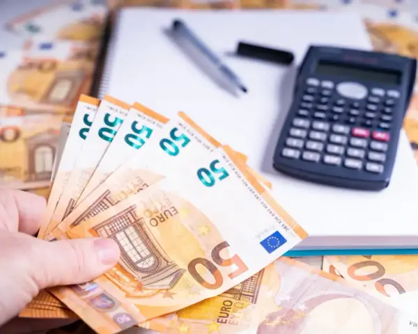 Ein Händchen hält 50-Euro-Scheine. Daneben liegen ein Taschenrechner und ein Notizbuch. Die Frage: bis wann muss man Unterhalt zahlen?