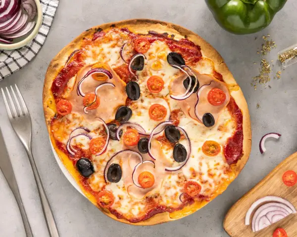 Pyszna pizza z szynką, oliwkami i pomidorkami. Proste ciasto na pizzę zawsze wychodzi, a składniki na blacie zachęcają do kolejnego kawałka.