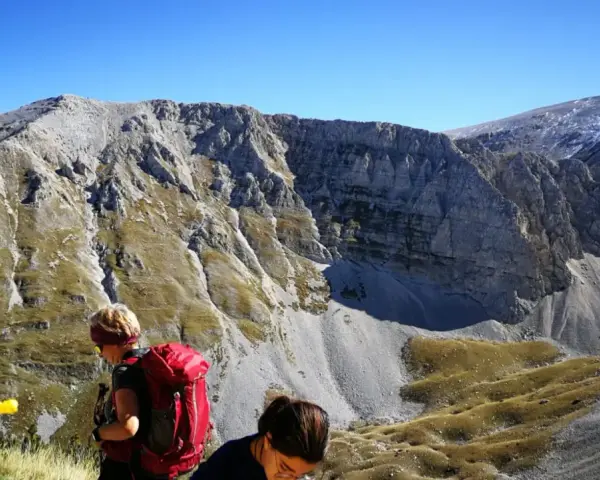 Escursionisti con zaini rossi ammirano il panorama montuoso vicino al bivacco Fusco.