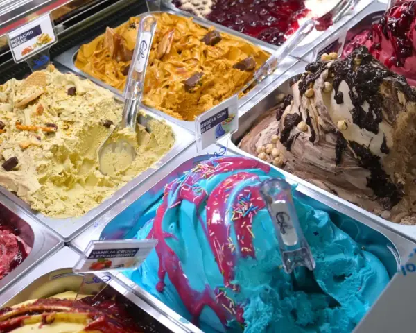 Verschiedene Sorten Eis: Pistazie, Karamell, Beeren, Schoko-Nuss und ein blaues Eis mit bunten Streuseln. Ein Fest für die Sinne!