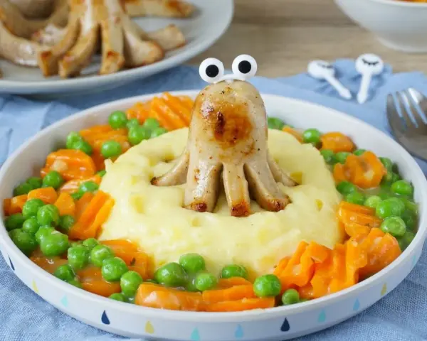 Kreatives Essen für Kinder: Wurst-Oktopus auf Kartoffelbrei mit Erbsen und Karotten. So macht das Backen Spaß!