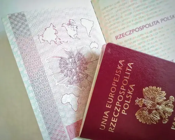 Polski paszport z godłem orła i mapą świata. Czy do Szwecji potrzebny jest paszport? Tak, jeśli podróżujesz spoza strefy Schengen.