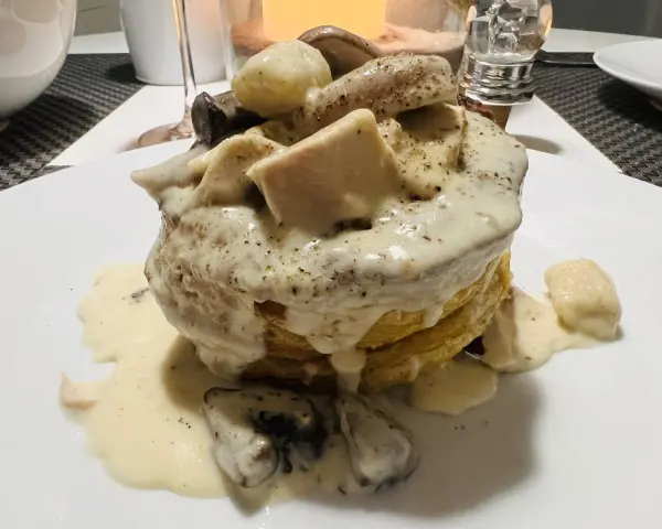 Une bouchée à la reine rapide, garnie de poulet, champignons et d'une sauce crémeuse, servie sur une pâte feuilletée dorée.