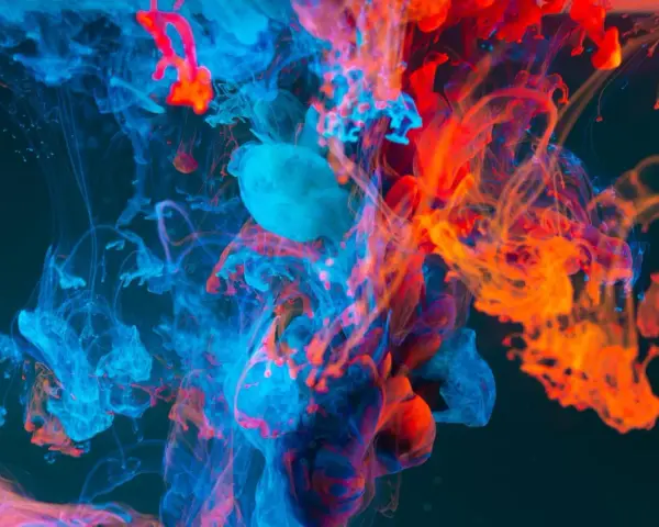 Nuvole di inchiostro blu e arancione si fondono in un vortice dinamico, evocando la potenza del colore nel cinema.