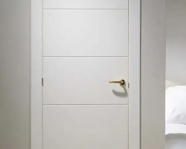 Puerta lacada en blanco con tirador dorado. Aprende como limpiar puertas lacadas en blanco para mantenerlas impecables.