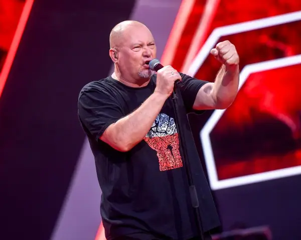 Tomasz Olejnik śpiewa z podniesioną pięścią, symbolizując siłę proletariatu.