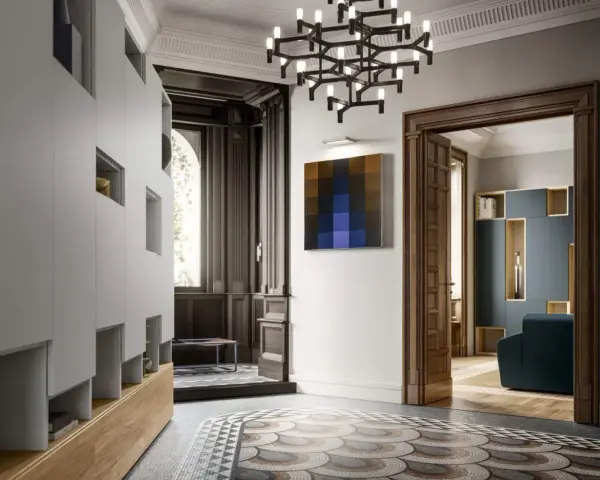 Ingresso di ville liberty moderne con arredi minimalisti, un quadro astratto e un lampadario scenografico.