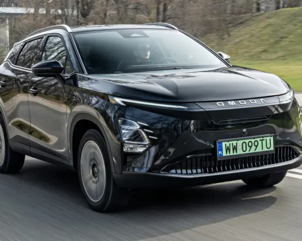 Czarny OMODA elektryk w ruchu drogowym. Nowoczesny design z charakterystycznym pasem świateł LED i logo marki.