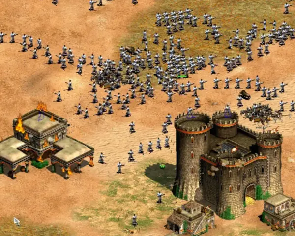 Un ejército avanza en Age of Empires 3, con edificios en llamas y un castillo imponente. ¡Descubre trucos para dominar el campo de batalla!