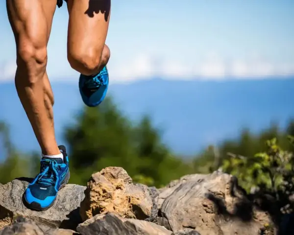 Nogi biegacza na kamienistym szlaku, przygotowującego się do ultramaratonu. Ile km jeszcze do mety?
