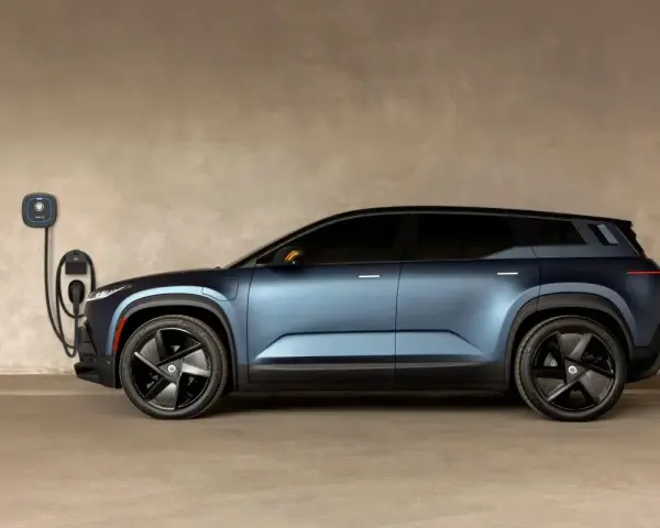 Niebieski Fisker Ocean zaparkowany przy ładowarce ściennej.