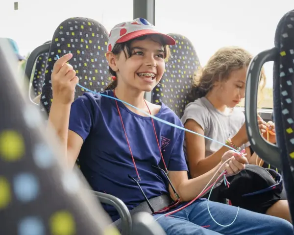 Deux enfants créatifs dans un bus, s'adonnant à une activité manuelle. Une belle illustration de l'éducation populaire en mouvement.