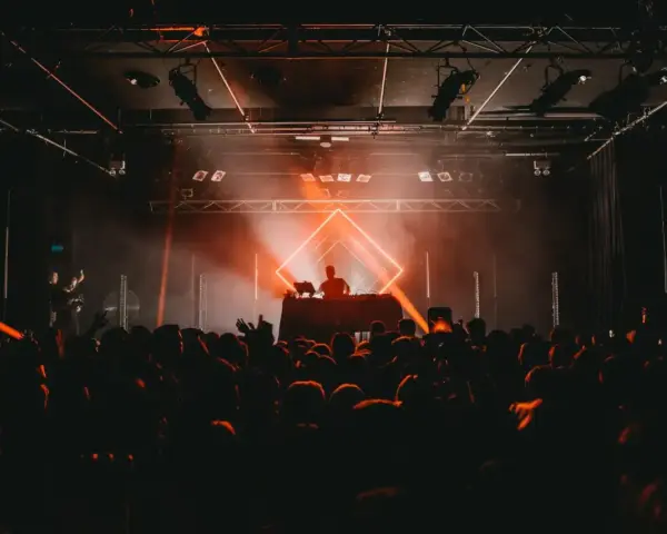 DJ legt auf, die Menge jubelt im Scheinwerferlicht. Ein pulsierendes Erlebnis im techno genre.