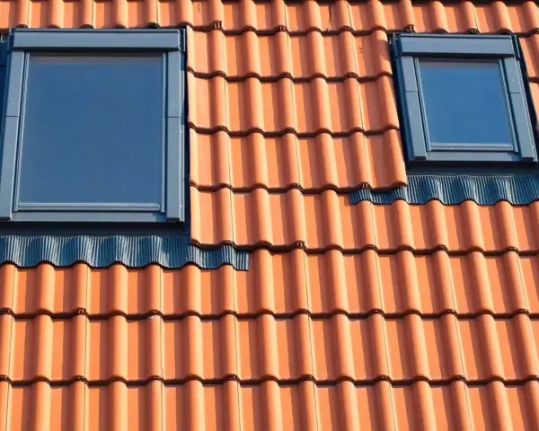Dwa małe okienka w dachu z dachówki ceramicznej.