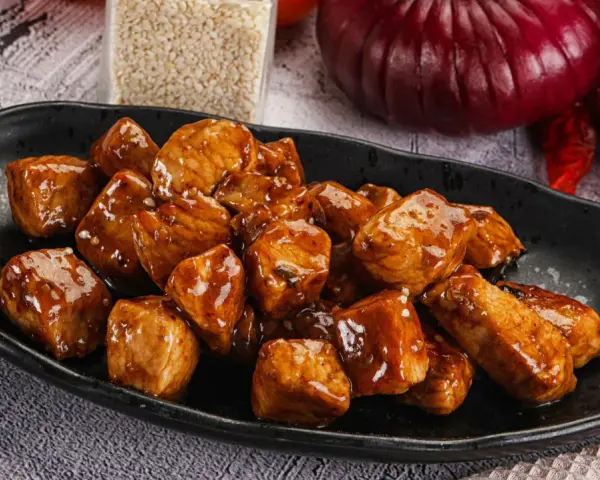 Kawałki indyka w sosie teriyaki, błyszczące i apetyczne, gotowe do podania.