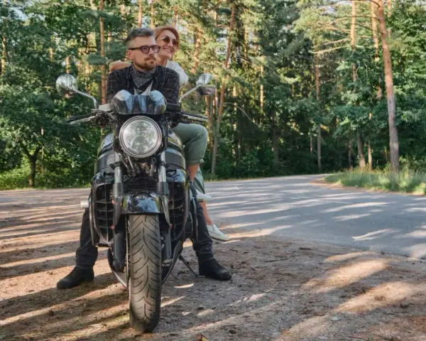 Para wyrusza na motocyklu przez las, marząc o podróży przez Karpaty i Sudety.