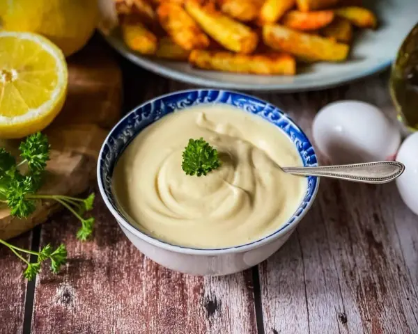 Cremige Mayonnaise, perfekt für Ihr nächstes mayonnaise rezept. Dazu passen goldbraune Pommes, frische Petersilie, Zitrone und Eier.
