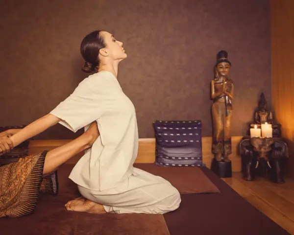 A woman receives a traditional Thai massage, a practice with a rich history rooted in ancient healing traditions.