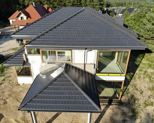 Nowy, ciemny dach z dachówki ceramicznej. Zastanawiasz się, ile kosztuje wymiana pokrycia dachowego?