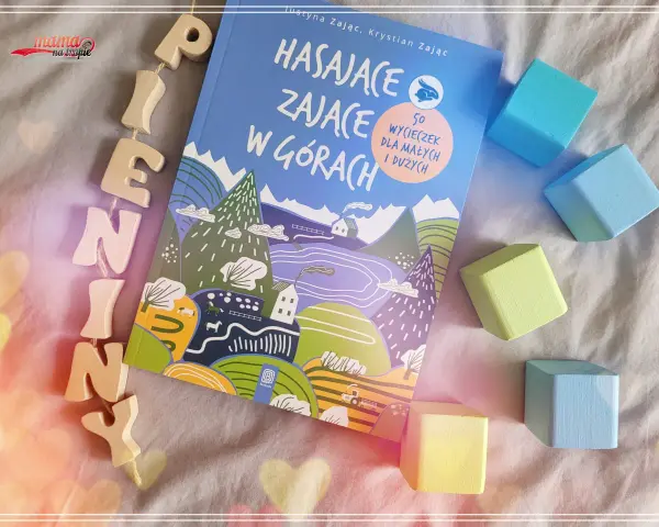 Książka "Hasające zające w górach" z drewnianymi literkami i kolorowymi klockami.