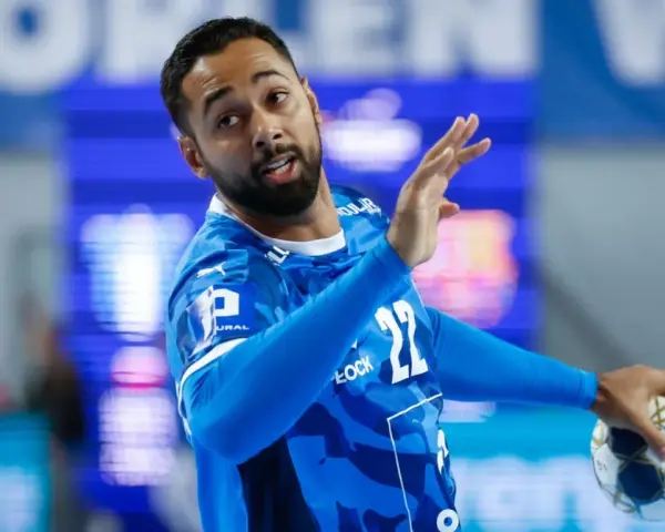 Gracz gog handball w niebieskiej koszulce z numerem 22, gotowy do rzutu.