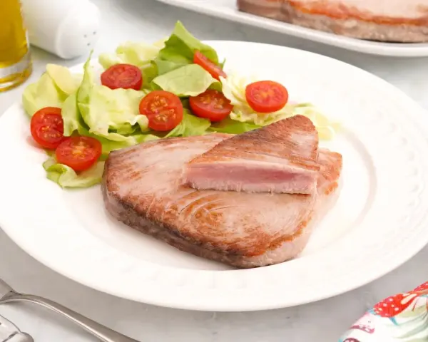 Delicioso atún a la plancha con ensalada fresca de lechuga y tomates cherry. Un plato ligero y saludable.